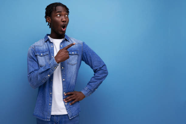 istock surprised stylish american young man with dreadlocks with a brilliant idea shows to the side 1936018043