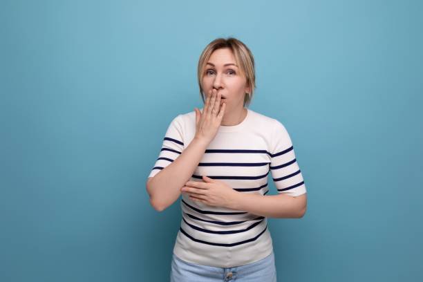 istock indignant blond girl in a striped sweater is surprised on a blue background with copy space 1936018607