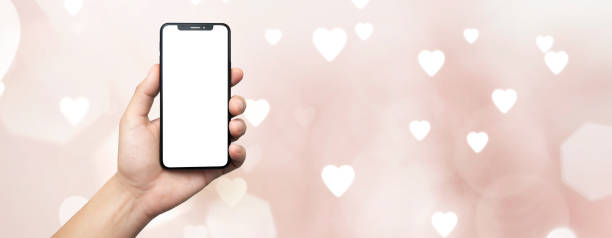 istock concept - cell phone in hand with heart background pink - easy modification 1936031519