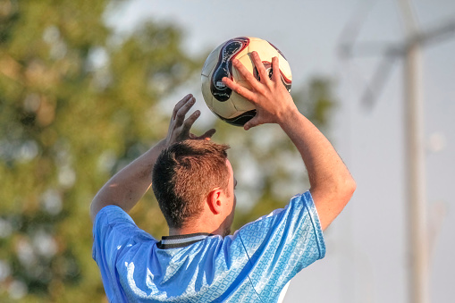 Calgary, Alberta, Canada. Jun 10, 2023. An aspiring football athlete executes a manual throw-in maneuver in the course of a soccer match held during the summer season.