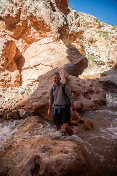 istock Man With Backpack Stands Knee Deep In Rushing Sulphur Creek 1936123556