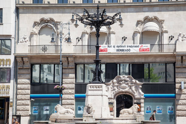 The facade of a typical historical building and a fountain in Pest, Budapest, Hungary