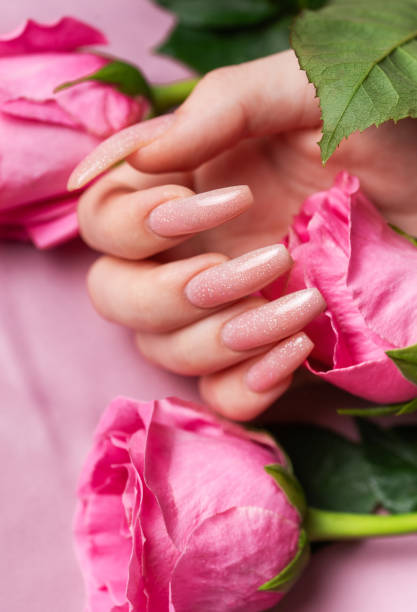 istock Female hands with pink nail design  hold pink roses 1936150927