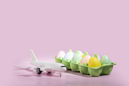 Huevos de Pascua y avión sobre fondo rosa, concepto de viaje de vacaciones, decoraciones de avia, vacaciones de primavera photo