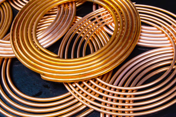 Twisted new copper tubes on a black background.