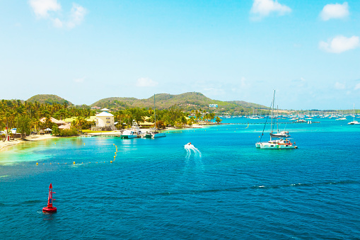 The coast of the island of Martinique in the Caribbean. Yachts, palm trees, beach and turquoise water.