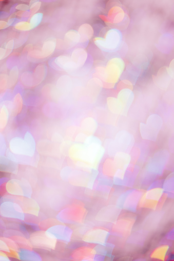 Abstract blurred vertical background with pink pastel color hearts, blurred lights as hearts bokeh, love or romance holiday fon, valentine Day festive screensaver or backdrop, color gradient photo