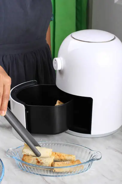 Woman Hand Taking Lumpia Out of Airfryer, Making Homemade Crispy Sweet Lumpia with Airfryer, Healthy Stule Snack without No Oil. Electric Kitchen Gadget for Non Fat Diet