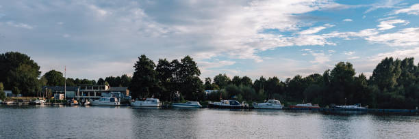 Bremen, Germany, Europe - September 20, 2023: photo of the german street. River Weser, boat and pier. Panoramic picture with touristic ships and forest.