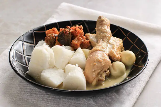 Photo of Lontong Opor, Indonesian White Curry with Chicken Drumstick and Quail Eggs, Chicken and Boiled Egg Cooked in Coconut Milk from Indonesia, Served with Lontong or Ketupat and Sambal. Popular Dish for Lebaran or Eid al-Fitr