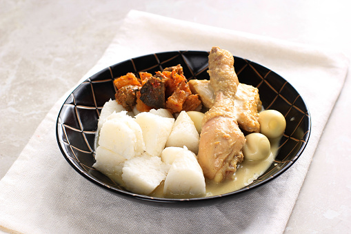 Lontong Opor, Indonesian White Curry with Chicken Drumstick and Quail Eggs, Chicken and Boiled Egg Cooked in Coconut Milk from Indonesia, Served with Lontong or Ketupat and Sambal. Popular Dish for Lebaran or Eid al-Fitr