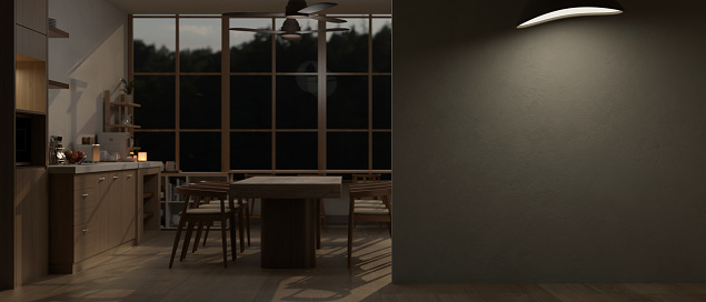 A modern spacious dark kitchen at night with a dining table and an empty wall mockup. 3d render, 3d illustration