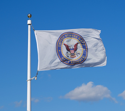 United State Navy - Navy Reserve flag waving against a blue sky background