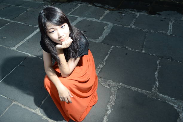 Portrait of a young lady sitting in a garden with fall colours.