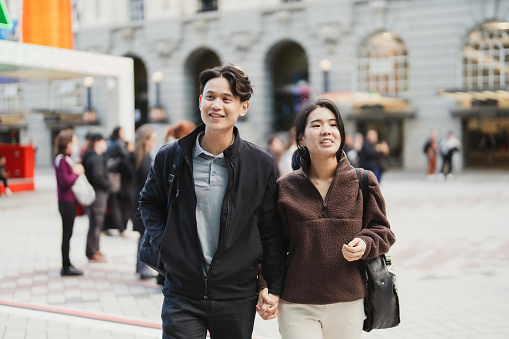 Happy young couple outdoors in the city together, spending leisure time together.