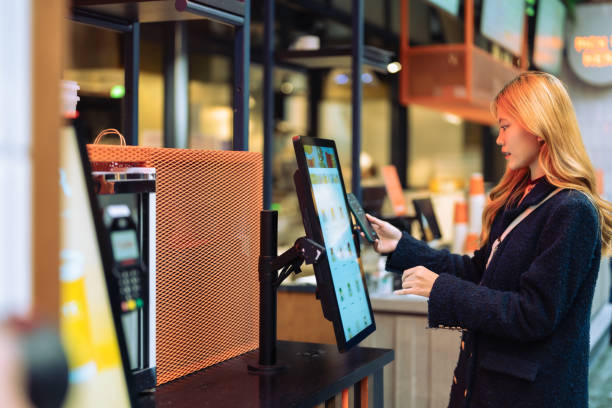 istock Self service checkout, woman using phone to pay. 1936539381