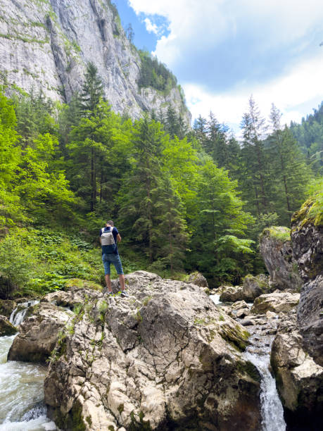 istock A guy is standing on large blocks of stone on a mountain river 1936611731