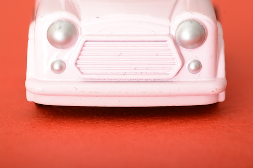 The close-up of a toy retro car highlights its miniature charm, offering a glimpse into the vintage design and craftsmanship that captures the essence of a simpler automotive era.