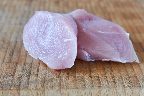 istock Raw turkey fillet on a wooden cutting board. Selective focus. 1936646593