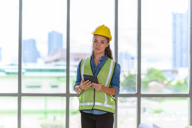 istock Portrait of female construction engineer workers in yellow hardhat with a tablet computer in construction site. 1936711232