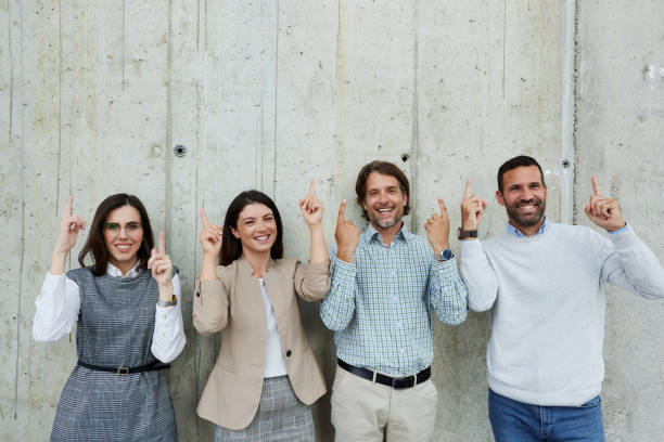 istock Happy entrepreneurs aiming at empty space on the wall in the office. 1936724171