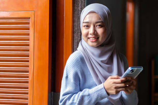 istock muslim woman using mobile phone 1936729943