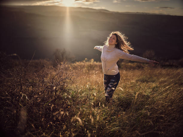 istock Carefree woman having fun on a hill at sunset. 1936737814