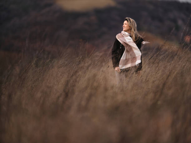 istock Happy woman walking in autumn day on a hill. 1936743113
