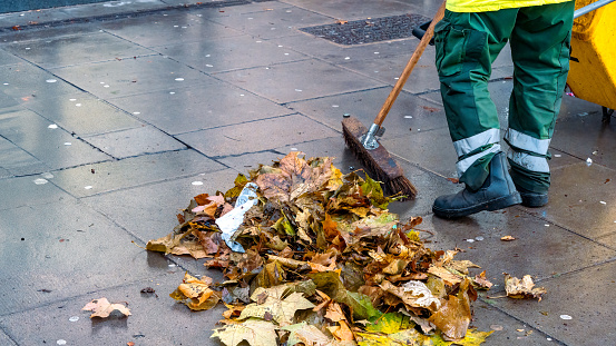 Street cleaners cleaning up a sidewalk in autumn