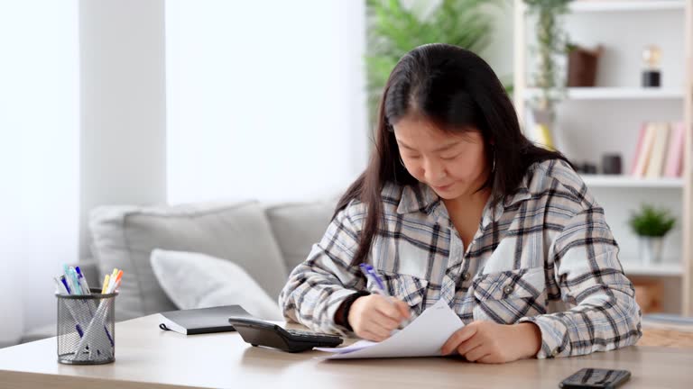 Chinese woman calculating home expenses