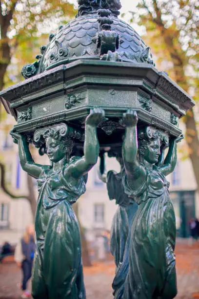 In Paris, a Wallace fountain supported by caryatids offers both a decorative element and a drinking water source, symbol of the city's commitment to public service and art. Travel and trip concepts