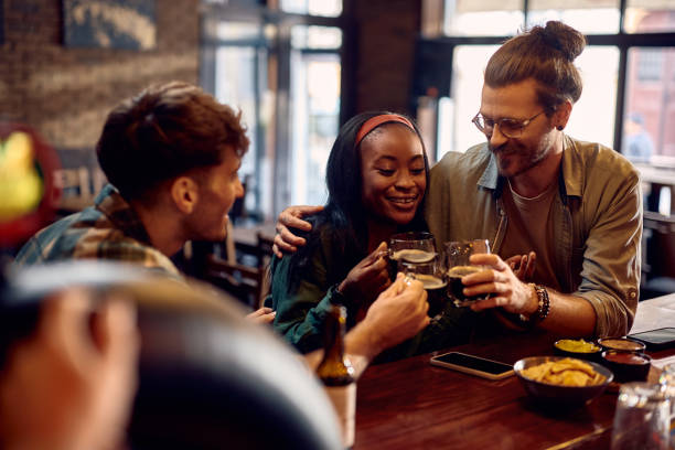istock Happy friends toasting while drinking beer in a pub. 1936799979