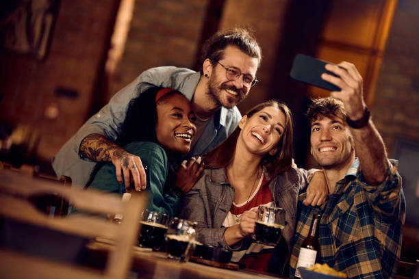 istock Young happy friends taking selfie while gathering in a bar. 1936799981