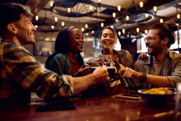 istock Cheerful friends toasting while drinking beer in a bar. 1936800521