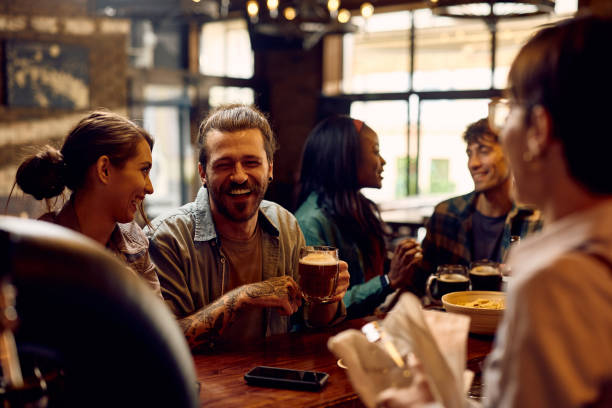istock Cheerful man having fun while drinking beer with friends in a pub. 1936802625