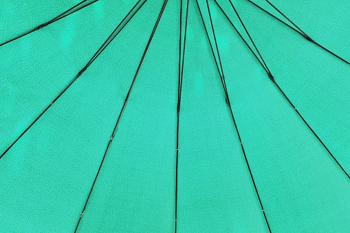 close up of under a green umbrella of its metal frames