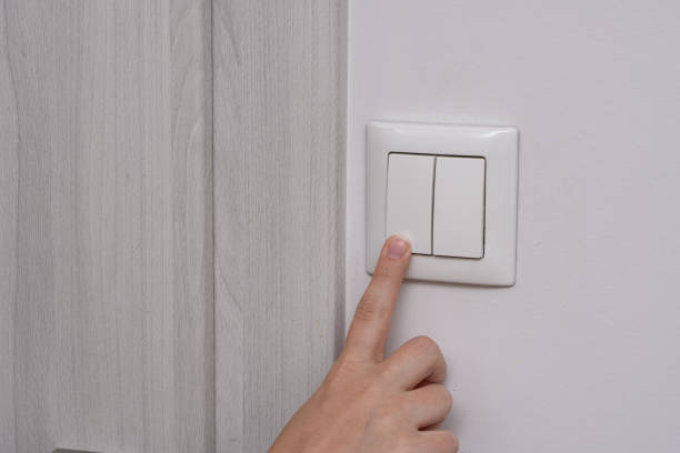 istock Turn on the light by pressing the light switch on the wall 1936814764