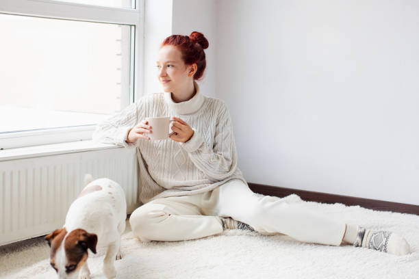istock Young Woman Drinking hot coffee at white room 1936828381