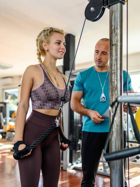 istock Personal trainer helping woman at gym 1936860381
