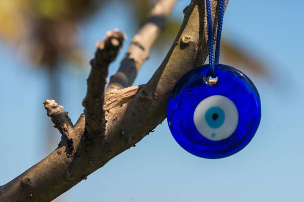 istock Closeup of a blue evil eye hanging on a tree branch 1936877577