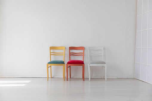 Three colorful vintage chairs in white room