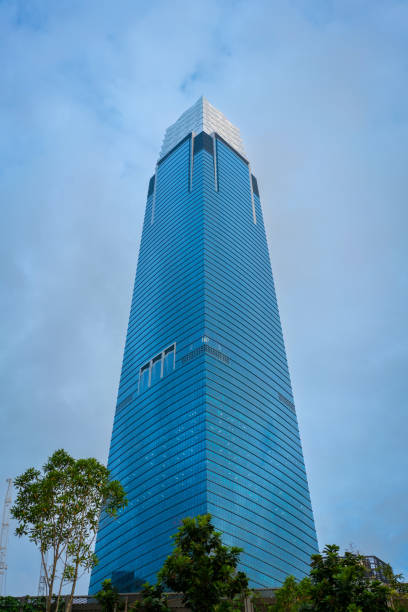 Bright lights fill the IFC Tower as it soars high into the night sky in Central District, showcasing modern architecture amidst the urban landscape of Hong Kong.