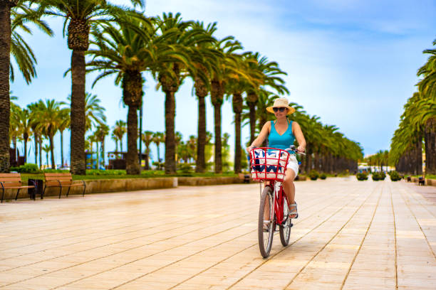 Mid adult woman riding bicycle at seaside