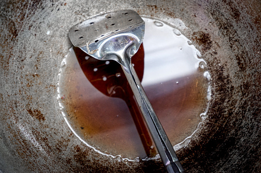 Spatula and Leftover cooking oil from frying in the pan