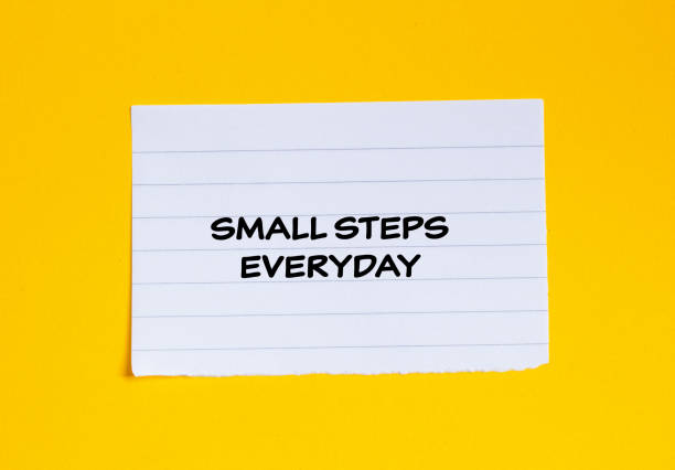 istock Small steps everyday lettering on ripped lined paper piece with yellow background 1936935977
