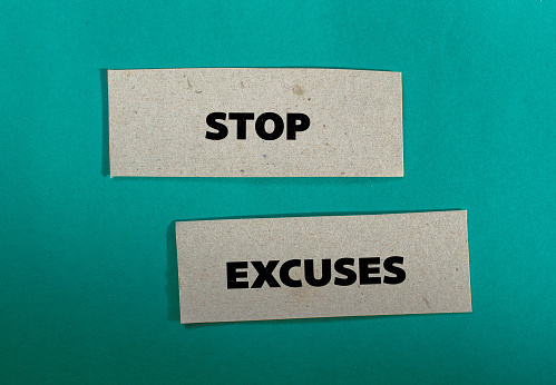 Stop excuses lettering on ripped paper pieces with blue background. Conceptual business photo. Top view, copy space.