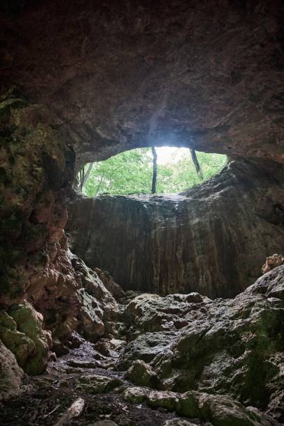 istock Large vertical cave, entrance from above, mountain landscape 1936952528