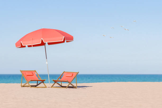 istock Beach Relaxation with Red Umbrella and Deck Chairs on Sandy Shore 1936957355