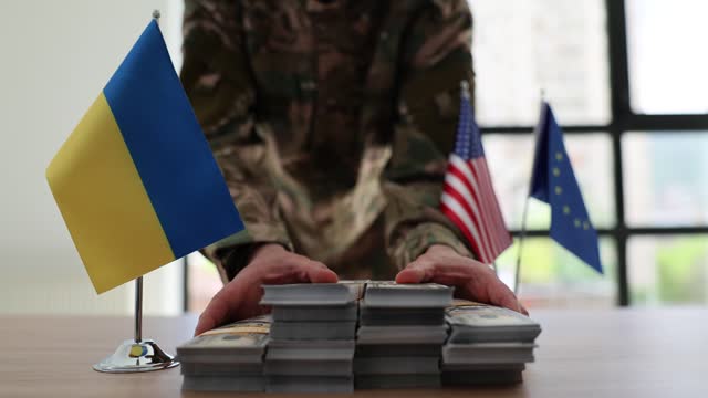 Military man passes bundles of American money at negotiating table of Ukraine with European Union and United States