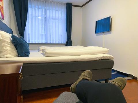 Side View Of Luxury Hotel Room With Two Beds, Chair And Potted Plant